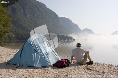 Image of Man sitting beside a tent