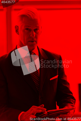 Image of senior business man working on tablet computer