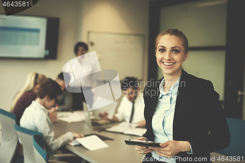 Image of business woman working on tablet at meeting room