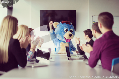 Image of boss dresed as bear having fun with business people in trendy of