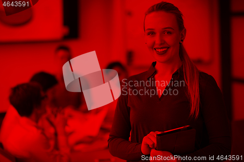 Image of blonde businesswoman working on tablet at office