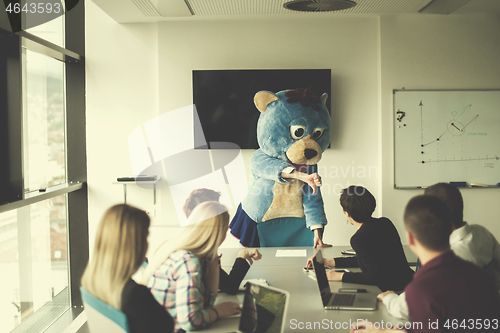 Image of boss dresed as bear having fun with business people in trendy of