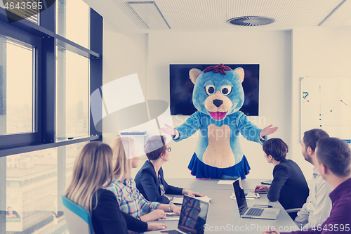 Image of boss dresed as bear having fun with business people in trendy of