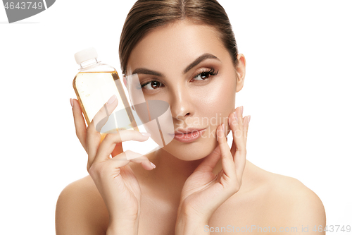 Image of Beauty concept. The pretty woman with perfect skin holding oil bottle