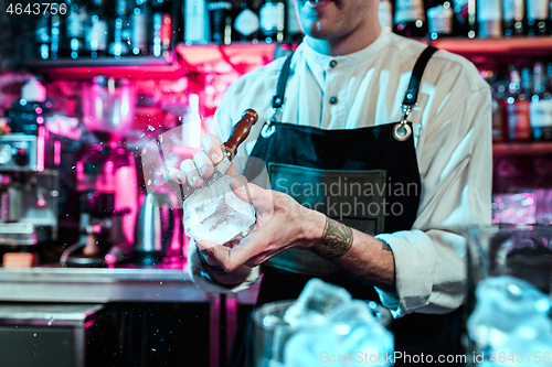 Image of Expert barman is making cocktail at night club.