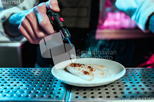 Image of Expert barman is making cocktail at night club.