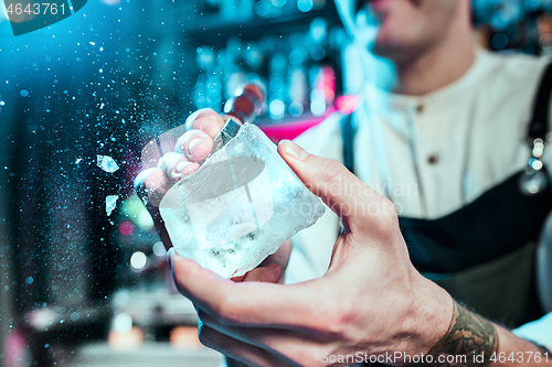 Image of Expert barman is making cocktail at night club.