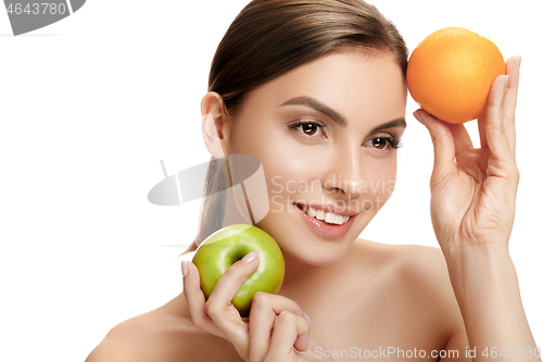 Image of portrait of attractive caucasian smiling woman isolated on white studio shot eating green apple