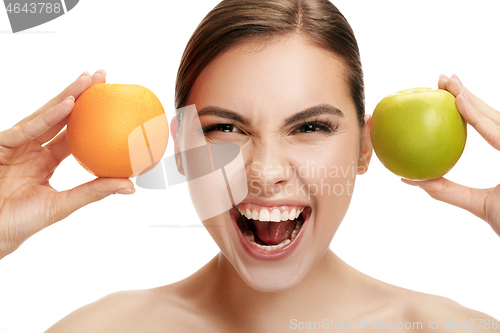 Image of portrait of attractive caucasian smiling woman isolated on white studio shot eating green apple
