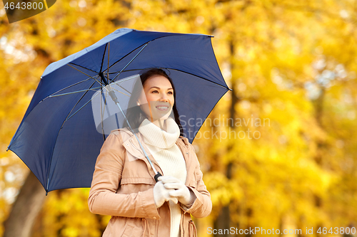 Image of happy woman with umbrella in autumn park