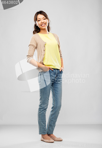 Image of happy asian woman over grey background