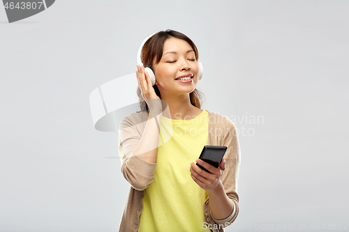 Image of asian woman in headphones listening to music