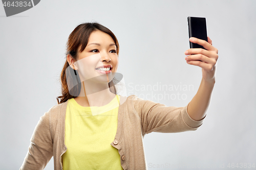 Image of asian woman taking selfie by smartphone