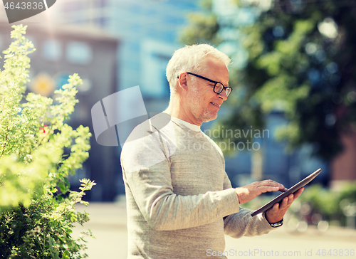 Image of senior man with tablet pc on city street