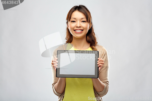 Image of happy asian woman showing tablet computer