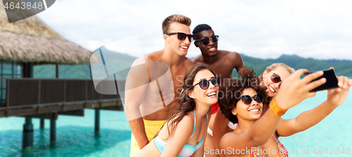Image of happy friends taking selfie on summer beach