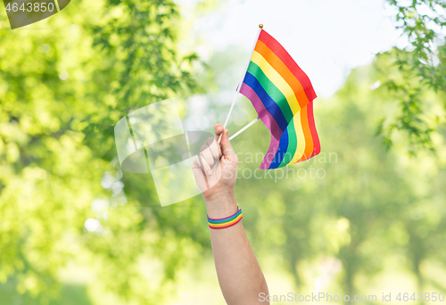 Image of hand with gay pride rainbow flags and wristband