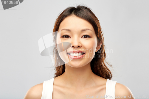 Image of face of happy smiling young asian woman