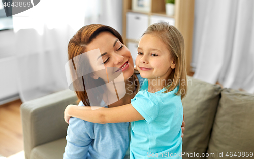 Image of little daughter hugging her mother at home