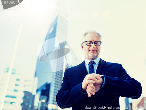 Image of senior businessman checking time on his wristwatch