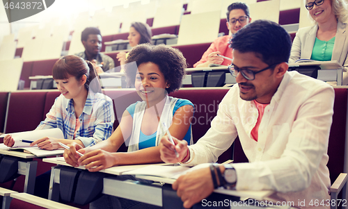 Image of group of students with notebooks in lecture hall