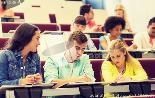 Image of group of students with notebooks in lecture hall