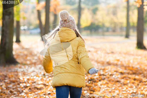 Image of happy girl running in autumn park