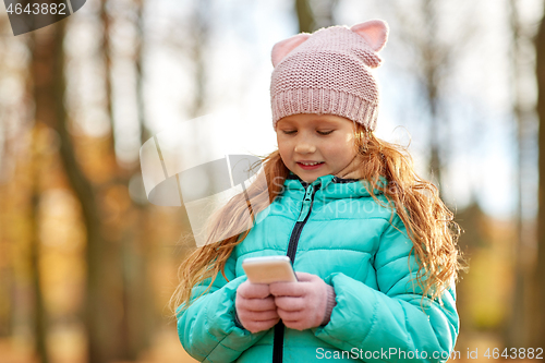 Image of girl with smartphone at autumn park