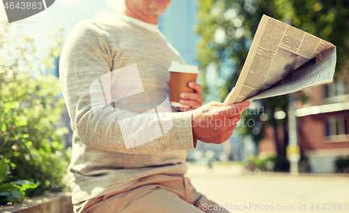 Image of senior man with coffee reading newspaper outdoors