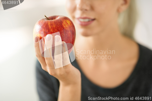 Image of close up of woman holding ripe red apple