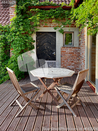 Image of terrace with wooden table and chairs