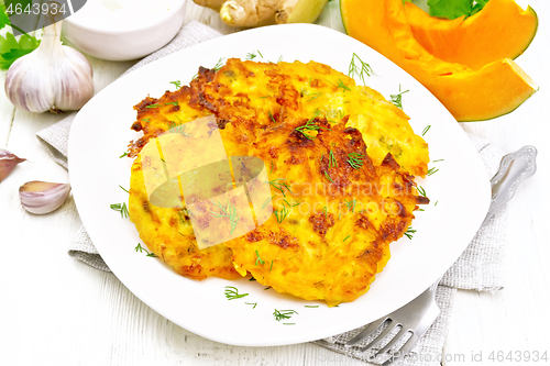 Image of Pancakes of pumpkin in plate on wooden board