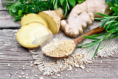 Image of Ginger ground in spoon with root on old board