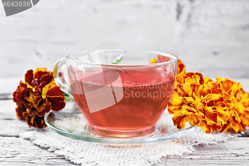 Image of Tea herbal of marigolds in cup on old board