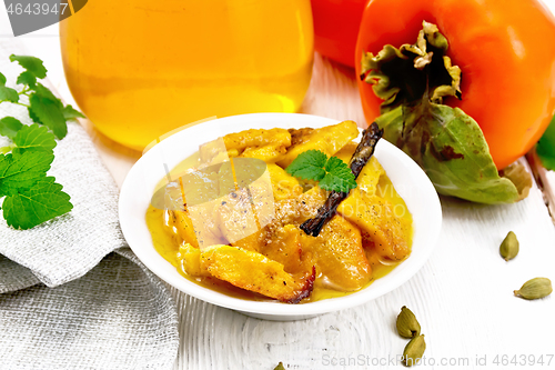 Image of Persimmons baked with honey in dish on wooden board