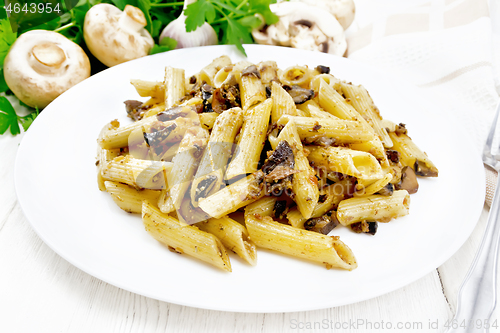 Image of Pasta with mushrooms in white plate on board