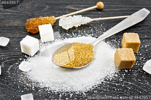 Image of Sugar brown in spoon and white on black board