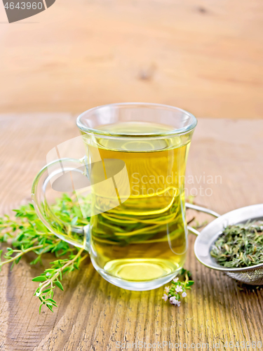 Image of Tea of thyme in mug with strainer on board