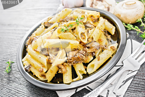 Image of Pasta with mushrooms in plate on dark board