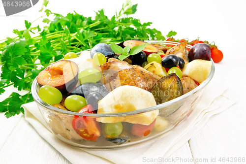 Image of Chicken with fruits and tomatoes in pan on wooden board
