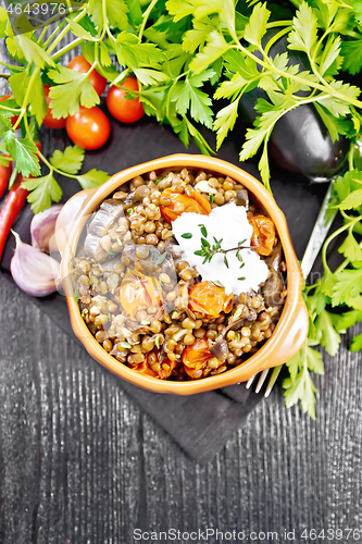 Image of Lentils with eggplant and tomatoes in bowl on board top