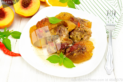 Image of Turkey with peaches in plate on wooden board