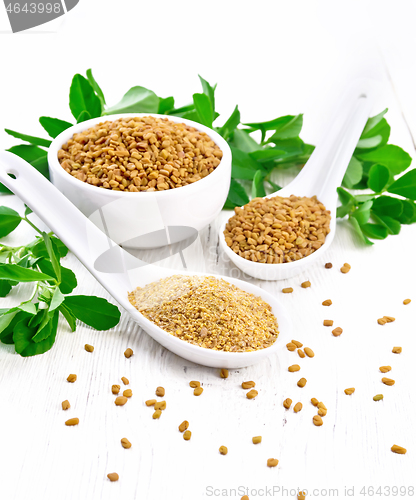 Image of Fenugreek in two spoons and bowl with leaves on wooden board