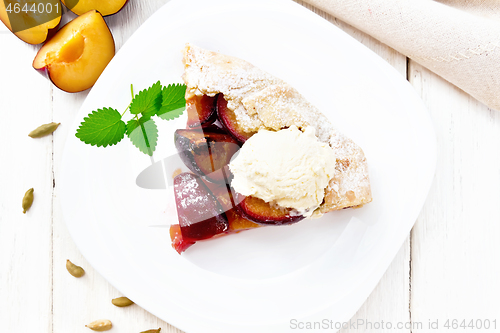 Image of Galeta with plums in plate on board top