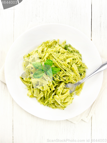 Image of Pasta with pesto sauce in plate on light board top