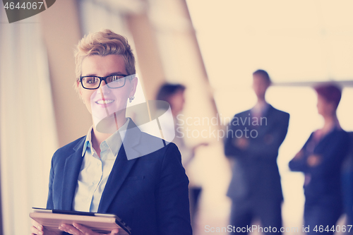 Image of business woman  at office with tablet  in front  as team leader