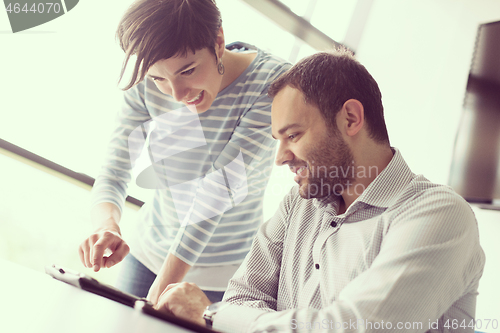 Image of Two Business People Working With Tablet in startup office