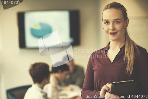 Image of blonde businesswoman working on tablet at office