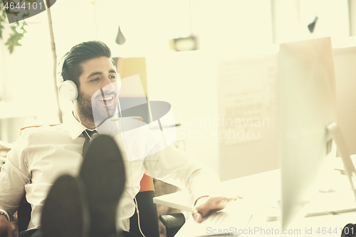 Image of relaxed young business man at office