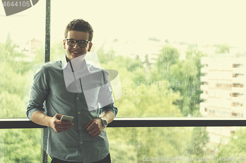 Image of Businessman Standing In A Modern Building Near The Window With P